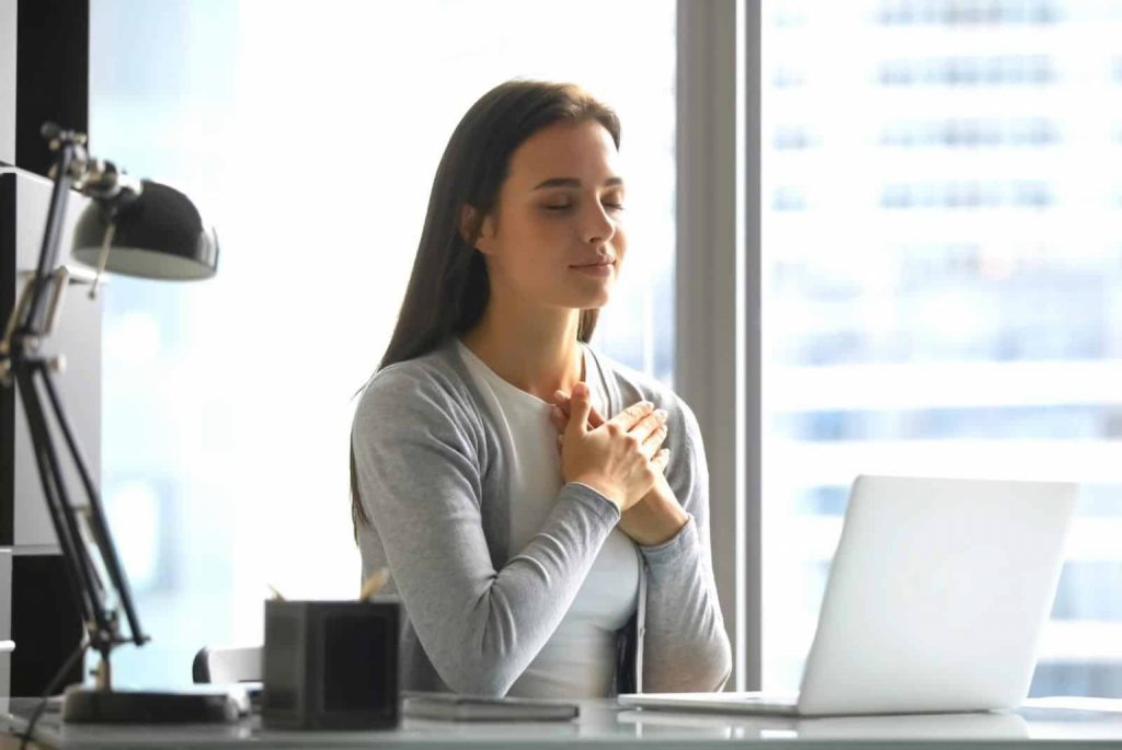 Young woman taking a moment to meditate at work - fizkes - getty images