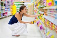 Woman reading labels on a supermarket shelf